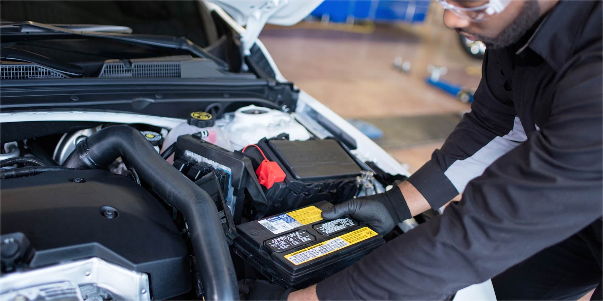A person is fitting battery into car