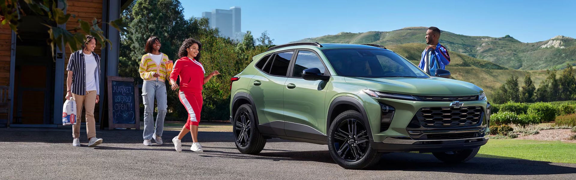Green Chevrolet Trax with family outdoors.