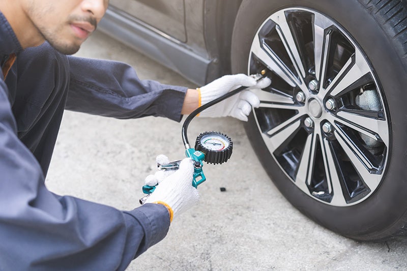 A mechanic checking tire pressure